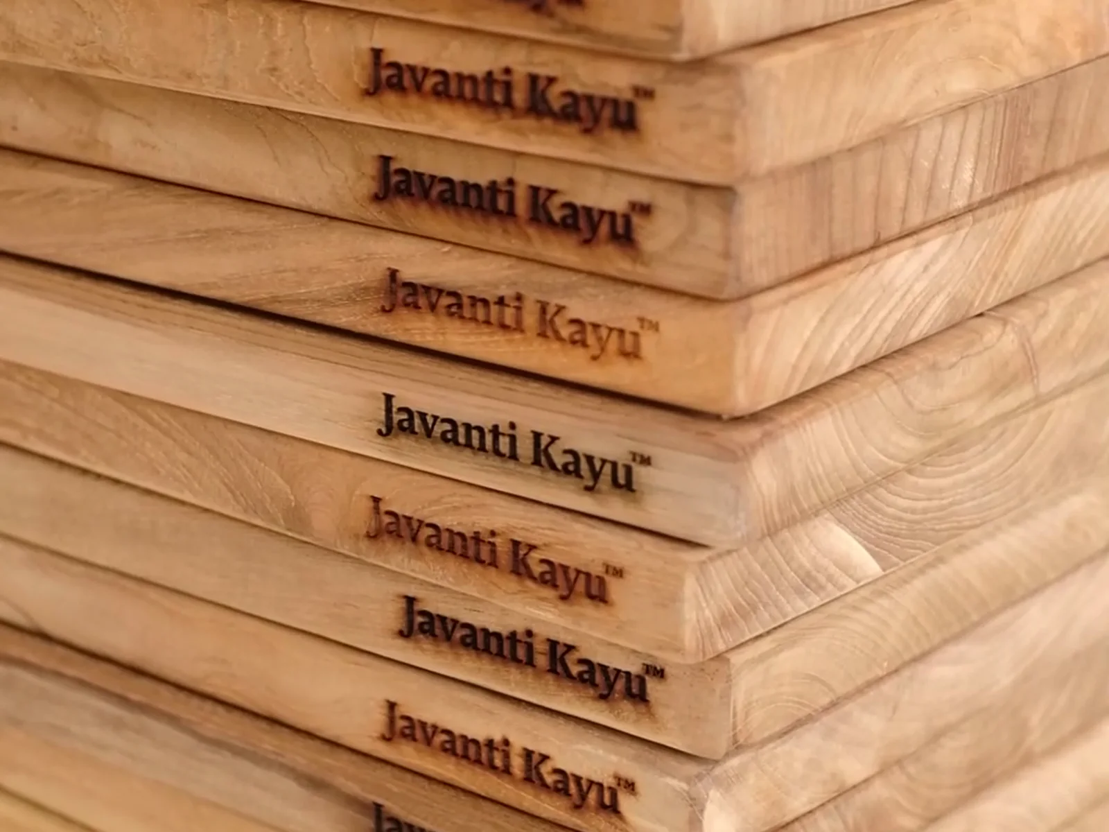 Finished teak boards stacked, each edge branded Javanti